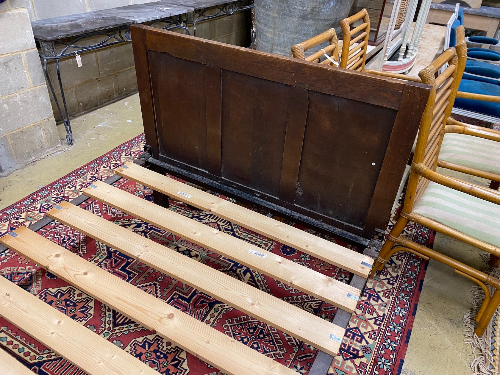 An 18th century style panelled oak bedframe, length 198cm, width 122cm, height 130cm